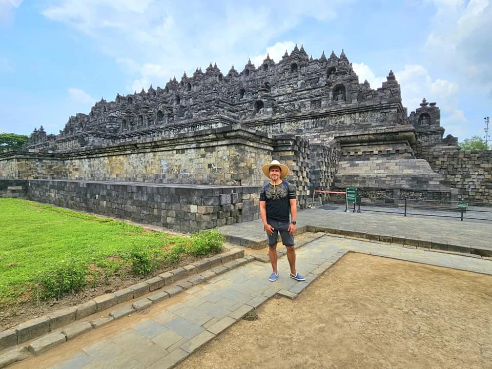 Cruising with Danny and Peter, Holland America Line, Westerdam, Semarang, Java, Indonesia, Borobudur Temple Cruise, Java Adventure | Panoramic view of Borobudur during a Borobudur Temple Cruise, showcasing the UNESCO Buddhist Temple amidst Central Java’s lush hills, with the Westerdam ship docked for the Holland America Westerdam Borobudur Tour, a Luxury Cruise Java adventure in Holland America Far East. Close-up of stupas and Buddha statues at Borobudur, reflecting Mahayana Buddhist Heritage, alongside a vibrant market scene from a Semarang Java Tour, part of an Indonesian Cultural Journey. Travelers explore this Borobudur Pilgrimage Site on a Central Java Travel excursion, enjoying a stunning sunset over the 9th-Century Temple Exploration, with detailed stone reliefs of the UNESCO Buddhist Temple and relaxation on the Westerdam deck during a Westerdam Cruise Indonesia.