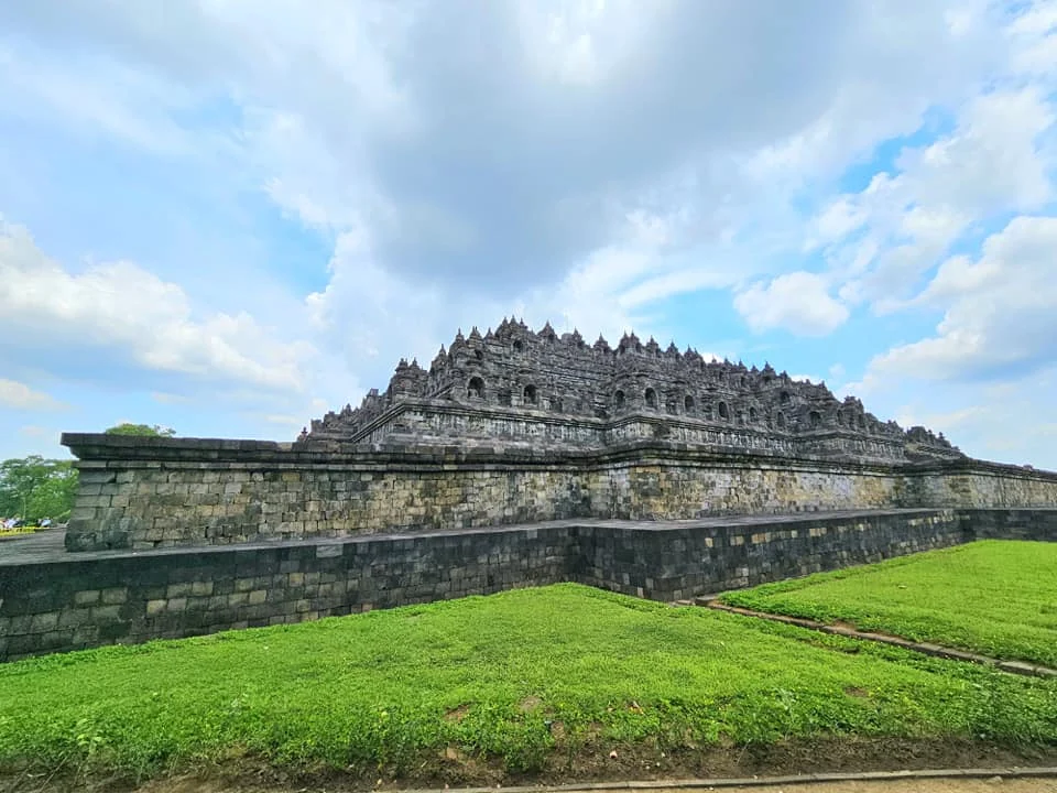 Cruising with Danny and Peter, Holland America Line, Westerdam, Semarang, Java, Indonesia, Borobudur Temple Cruise, Java Adventure | Panoramic view of Borobudur during a Borobudur Temple Cruise, showcasing the UNESCO Buddhist Temple amidst Central Java’s lush hills, with the Westerdam ship docked for the Holland America Westerdam Borobudur Tour, a Luxury Cruise Java adventure in Holland America Far East. Close-up of stupas and Buddha statues at Borobudur, reflecting Mahayana Buddhist Heritage, alongside a vibrant market scene from a Semarang Java Tour, part of an Indonesian Cultural Journey. Travelers explore this Borobudur Pilgrimage Site on a Central Java Travel excursion, enjoying a stunning sunset over the 9th-Century Temple Exploration, with detailed stone reliefs of the UNESCO Buddhist Temple and relaxation on the Westerdam deck during a Westerdam Cruise Indonesia.