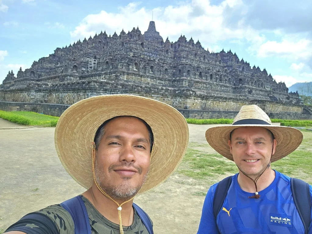 Cruising with Danny and Peter, Holland America Line, Westerdam, Semarang, Java, Indonesia, Borobudur Temple Cruise, Java Adventure | Panoramic view of Borobudur during a Borobudur Temple Cruise, showcasing the UNESCO Buddhist Temple amidst Central Java’s lush hills, with the Westerdam ship docked for the Holland America Westerdam Borobudur Tour, a Luxury Cruise Java adventure in Holland America Far East. Close-up of stupas and Buddha statues at Borobudur, reflecting Mahayana Buddhist Heritage, alongside a vibrant market scene from a Semarang Java Tour, part of an Indonesian Cultural Journey. Travelers explore this Borobudur Pilgrimage Site on a Central Java Travel excursion, enjoying a stunning sunset over the 9th-Century Temple Exploration, with detailed stone reliefs of the UNESCO Buddhist Temple and relaxation on the Westerdam deck during a Westerdam Cruise Indonesia.