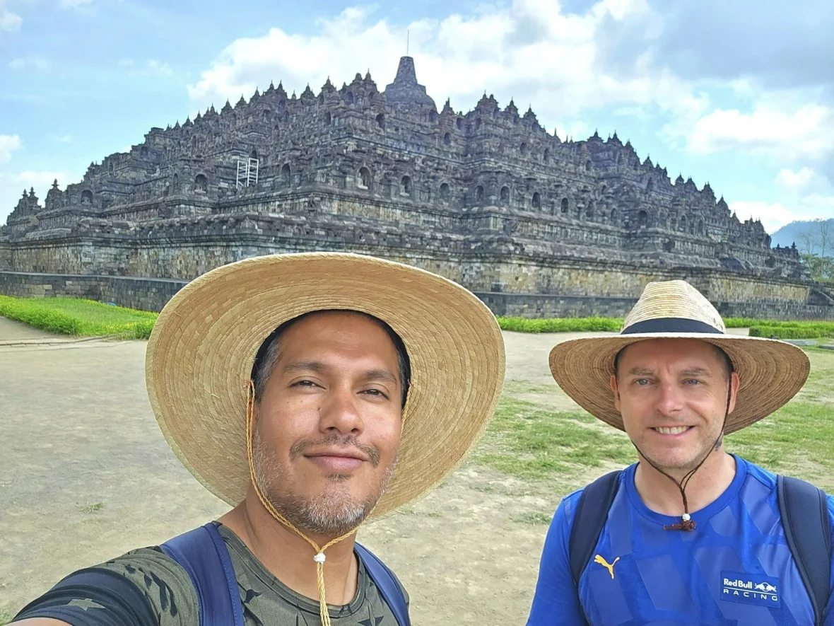 Cruising with Danny and Peter, Holland America Line, Westerdam, Semarang, Java, Indonesia, Borobudur Temple Cruise, Java Adventure | Panoramic view of Borobudur during a Borobudur Temple Cruise, showcasing the UNESCO Buddhist Temple amidst Central Java’s lush hills, with the Westerdam ship docked for the Holland America Westerdam Borobudur Tour, a Luxury Cruise Java adventure in Holland America Far East. Close-up of stupas and Buddha statues at Borobudur, reflecting Mahayana Buddhist Heritage, alongside a vibrant market scene from a Semarang Java Tour, part of an Indonesian Cultural Journey. Travelers explore this Borobudur Pilgrimage Site on a Central Java Travel excursion, enjoying a stunning sunset over the 9th-Century Temple Exploration, with detailed stone reliefs of the UNESCO Buddhist Temple and relaxation on the Westerdam deck during a Westerdam Cruise Indonesia.