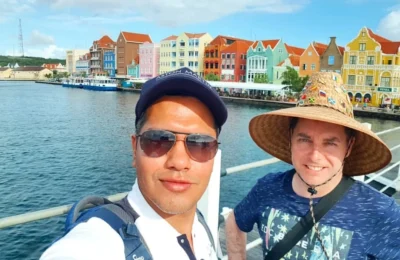 Cruising with Danny and Peter, Holland America Line, Zuiderdam, Willemstad, Curacao | Pristine sandy beach and turquoise waters at Wet & Wild Beach Club in Willemstad, Curaçao, featuring snorkeling enthusiasts exploring vibrant coral reefs, thrilling water sports like jet skiing and parasailing, and a spectacular sunset view from the beachfront bar, showcasing the ultimate Caribbean beach resort experience.