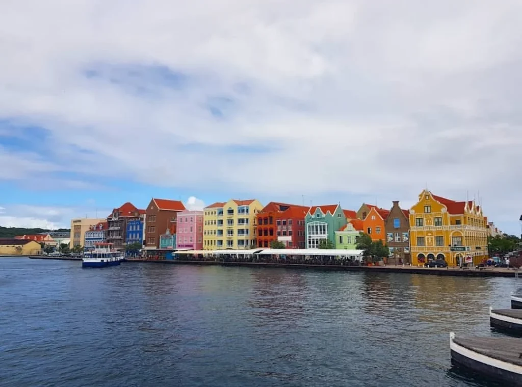 Cruising with Danny and Peter, Holland America Line, Zuiderdam, Willemstad, Curacao | Pristine sandy beach and turquoise waters at Wet & Wild Beach Club in Willemstad, Curaçao, featuring snorkeling enthusiasts exploring vibrant coral reefs, thrilling water sports like jet skiing and parasailing, and a spectacular sunset view from the beachfront bar, showcasing the ultimate Caribbean beach resort experience.