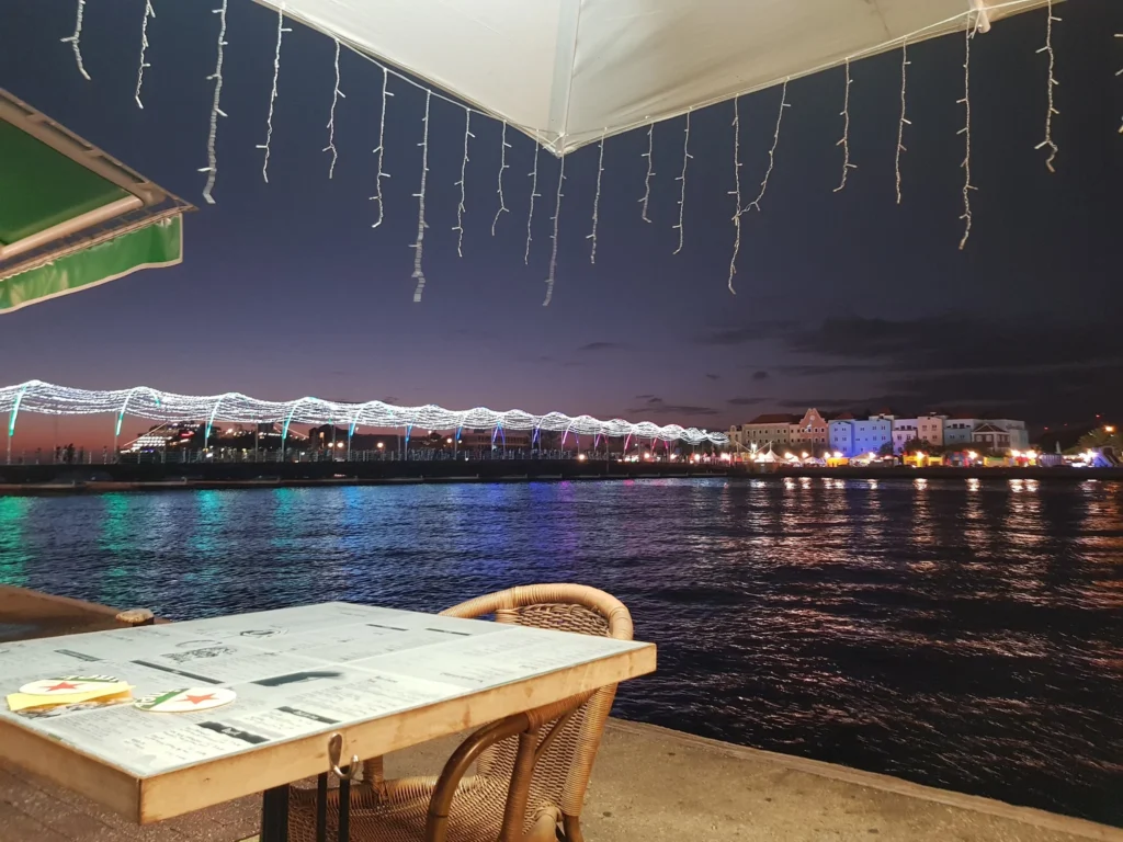 Cruising with Danny and Peter, Holland America Line, Zuiderdam, Willemstad, Curacao | Pristine sandy beach and turquoise waters at Wet & Wild Beach Club in Willemstad, Curaçao, featuring snorkeling enthusiasts exploring vibrant coral reefs, thrilling water sports like jet skiing and parasailing, and a spectacular sunset view from the beachfront bar, showcasing the ultimate Caribbean beach resort experience.