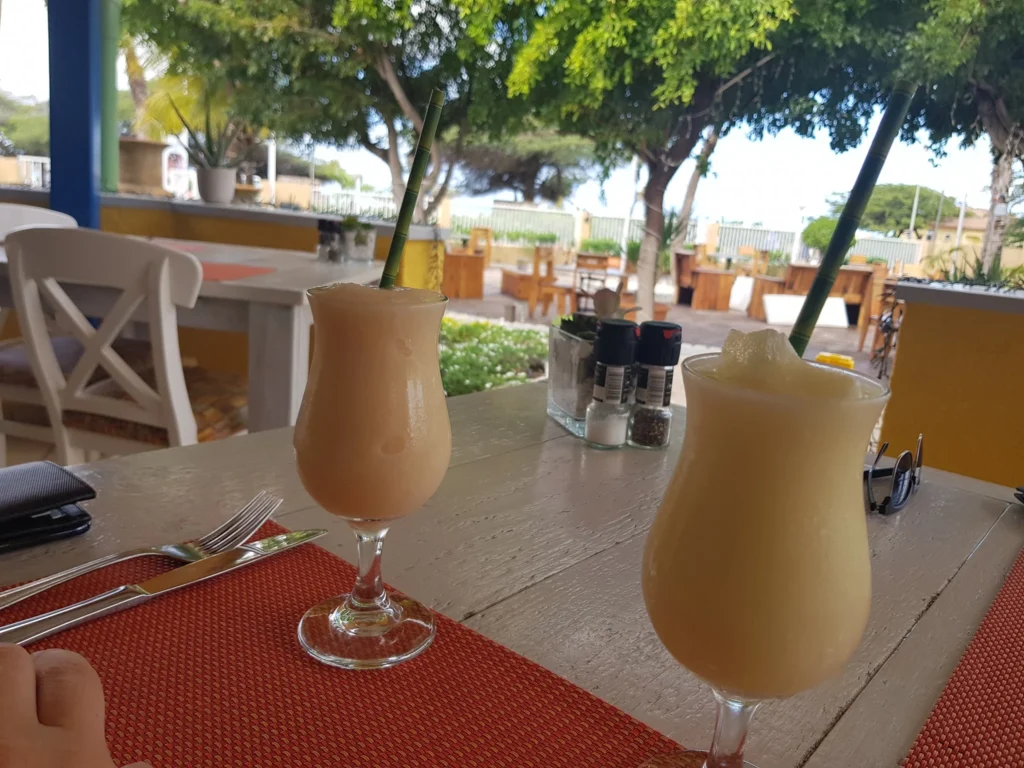 Cruising with Danny and Peter, Holland America Line, Zuiderdam, Oranjestad, Aruba | Vibrant view of Oranjestad Beach with powdery sands and turquoise waters during a relaxing beach day in Aruba, showcasing local beachfront dining and coastal activities.