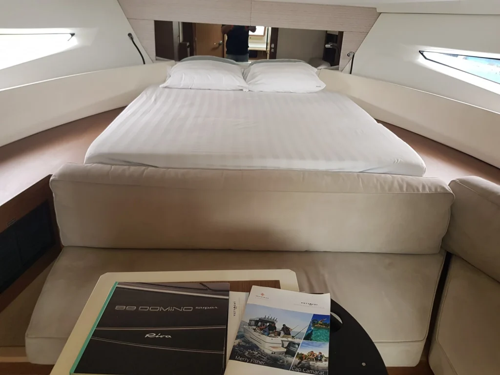 Cruising with Danny and Peter, Holland America Line, Westerdam, Halong Bay, Vietnam | A stunning view of the Hạ Long Bay Yacht cruising through emerald waters, surrounded by majestic limestone karsts. Guests enjoy Vietnamese seafood dining on the deck while kayaking in Hạ Long Bay. The private yacht tour showcases the beauty of this UNESCO World Heritage site.