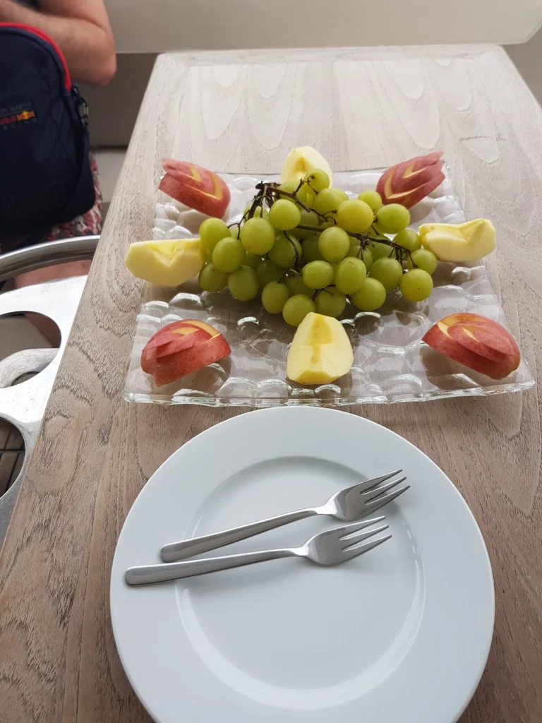 Cruising with Danny and Peter, Holland America Line, Westerdam, Halong Bay, Vietnam | A stunning view of the Hạ Long Bay Yacht cruising through emerald waters, surrounded by majestic limestone karsts. Guests enjoy Vietnamese seafood dining on the deck while kayaking in Hạ Long Bay. The private yacht tour showcases the beauty of this UNESCO World Heritage site.