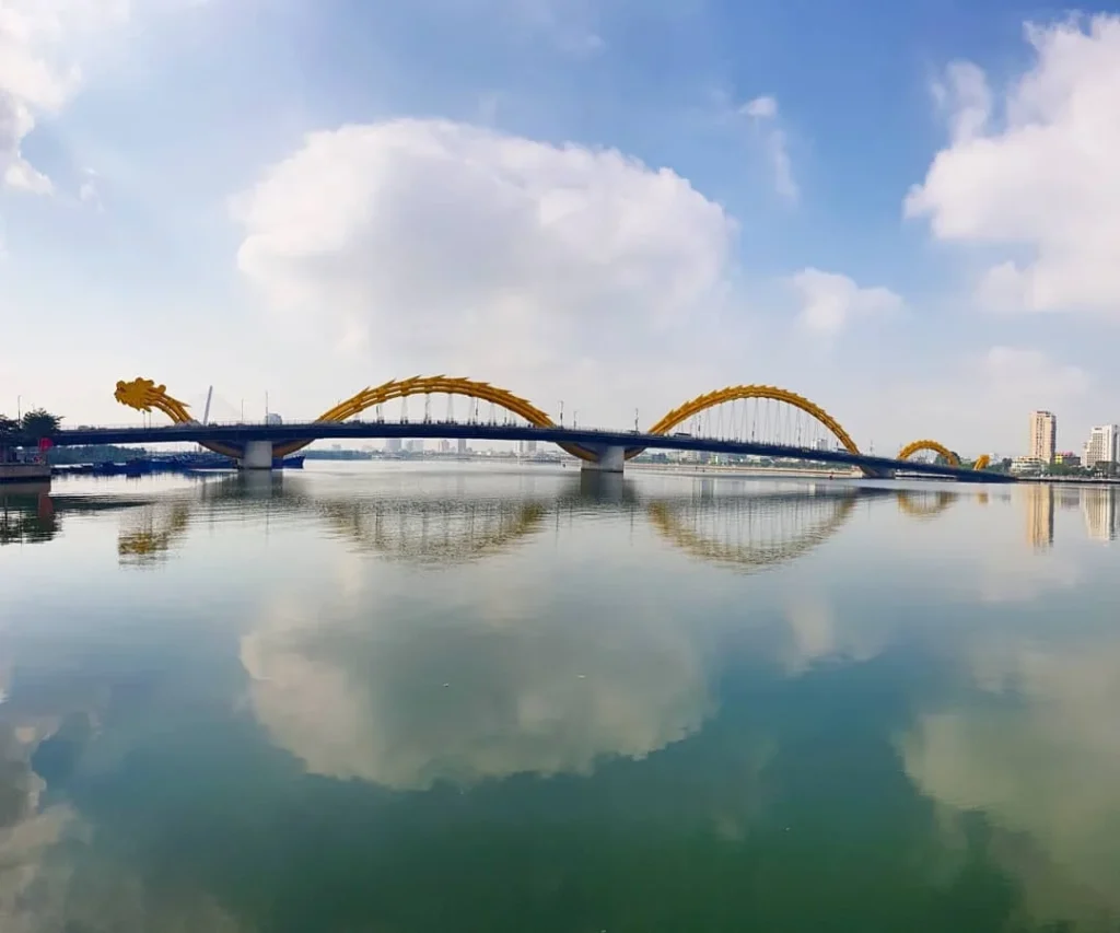 Cruising with Danny and Peter, Holland America Line, Westerdam, Da Nang, Hue, Vietnam | A vibrant street scene in Đà Nẵng showcasing a bustling market filled with fresh produce and aromatic spices, capturing the essence of Vietnamese cuisine. Motorbikes are parked nearby, symbolizing the thrilling motorbike street food tour. An enticing plate of bánh mì and bowls of pho are featured prominently, representing the local street eats enjoyed during this culinary exploration.