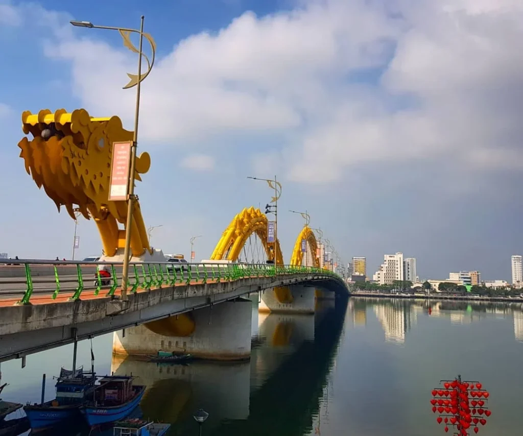 Cruising with Danny and Peter, Holland America Line, Westerdam, Da Nang, Hue, Vietnam | A vibrant street scene in Đà Nẵng showcasing a bustling market filled with fresh produce and aromatic spices, capturing the essence of Vietnamese cuisine. Motorbikes are parked nearby, symbolizing the thrilling motorbike street food tour. An enticing plate of bánh mì and bowls of pho are featured prominently, representing the local street eats enjoyed during this culinary exploration.