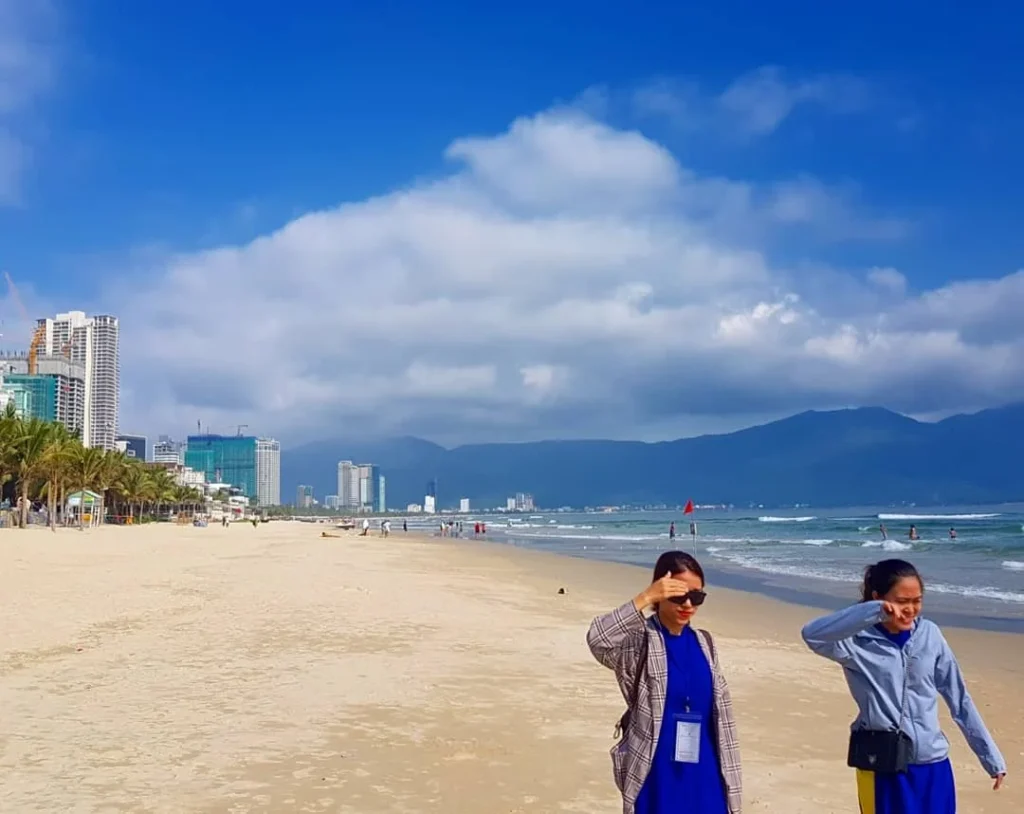 Cruising with Danny and Peter, Holland America Line, Westerdam, Da Nang, Hue, Vietnam | A vibrant street scene in Đà Nẵng showcasing a bustling market filled with fresh produce and aromatic spices, capturing the essence of Vietnamese cuisine. Motorbikes are parked nearby, symbolizing the thrilling motorbike street food tour. An enticing plate of bánh mì and bowls of pho are featured prominently, representing the local street eats enjoyed during this culinary exploration.
