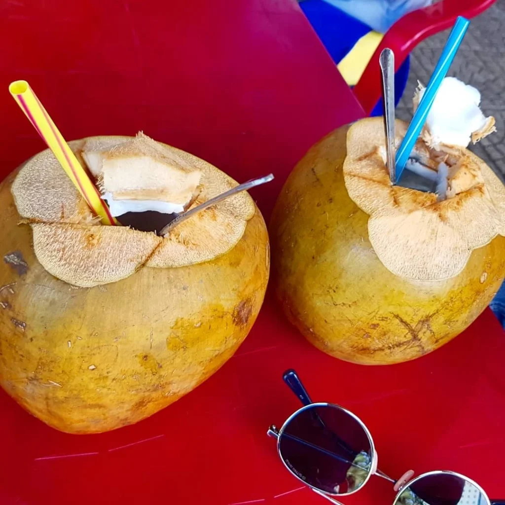 Cruising with Danny and Peter, Holland America Line, Westerdam, Da Nang, Hue, Vietnam | A vibrant street scene in Đà Nẵng showcasing a bustling market filled with fresh produce and aromatic spices, capturing the essence of Vietnamese cuisine. Motorbikes are parked nearby, symbolizing the thrilling motorbike street food tour. An enticing plate of bánh mì and bowls of pho are featured prominently, representing the local street eats enjoyed during this culinary exploration.