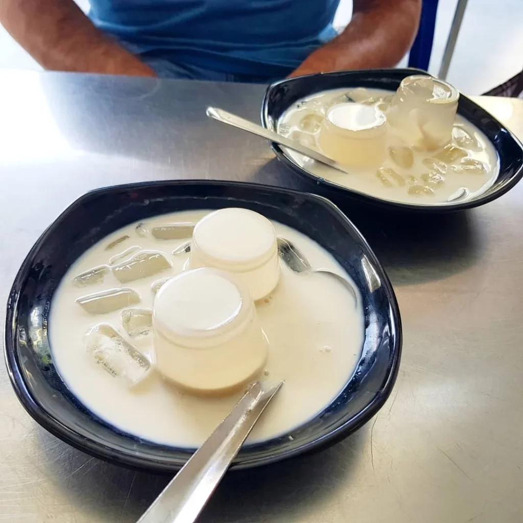 Cruising with Danny and Peter, Holland America Line, Westerdam, Da Nang, Hue, Vietnam | A vibrant street scene in Đà Nẵng showcasing a bustling market filled with fresh produce and aromatic spices, capturing the essence of Vietnamese cuisine. Motorbikes are parked nearby, symbolizing the thrilling motorbike street food tour. An enticing plate of bánh mì and bowls of pho are featured prominently, representing the local street eats enjoyed during this culinary exploration.