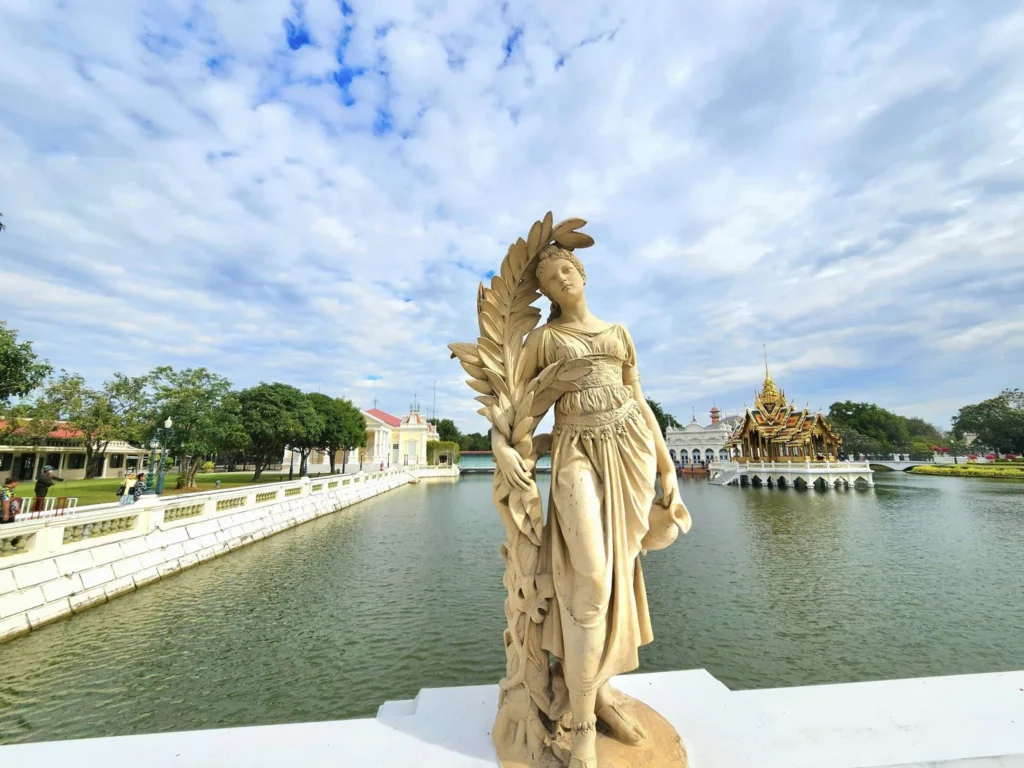A Majestic Journey: Unveiling the Royal Historical Tour Ayutthaya from the Holland America Cruise 15 Cruising with Danny and Peter, Holland America Line, Westerdam, Laem Chabang, Bangkok, Thailand, Royal Historical Tour Ayutthaya 5 Glorious Stops | Exploring the Royal Historical Tour Ayutthaya and Bang Pa In Ayutthaya with lush gardens at Bang Pa In Palace, the elegant Aisawan Dhipaya Pavilion on a tranquil lake, towering stupa and Buddha statues at Ayutthaya Temples, colorful Traditional Thai Cuisine, and the iconic Buddha head in tree roots at Wat Mahathat Ruins—a UNESCO Heritage Site—all part of an unforgettable Thailand Cultural Tour and Ayutthaya Day Trip from the Holland America Cruise, showcasing Thai Royal History.