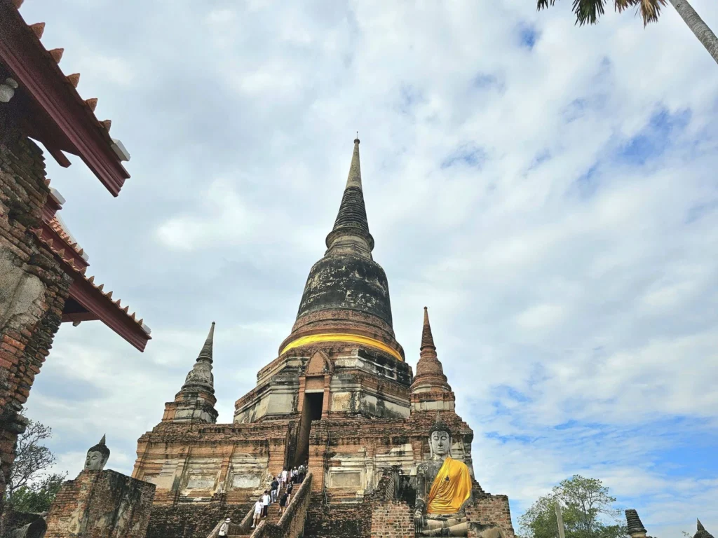 A Majestic Journey: Unveiling the Royal Historical Tour Ayutthaya from the Holland America Cruise 39 Cruising with Danny and Peter, Holland America Line, Westerdam, Laem Chabang, Bangkok, Thailand, Royal Historical Tour Ayutthaya 5 Glorious Stops | Exploring the Royal Historical Tour Ayutthaya and Bang Pa In Ayutthaya with lush gardens at Bang Pa In Palace, the elegant Aisawan Dhipaya Pavilion on a tranquil lake, towering stupa and Buddha statues at Ayutthaya Temples, colorful Traditional Thai Cuisine, and the iconic Buddha head in tree roots at Wat Mahathat Ruins—a UNESCO Heritage Site—all part of an unforgettable Thailand Cultural Tour and Ayutthaya Day Trip from the Holland America Cruise, showcasing Thai Royal History.