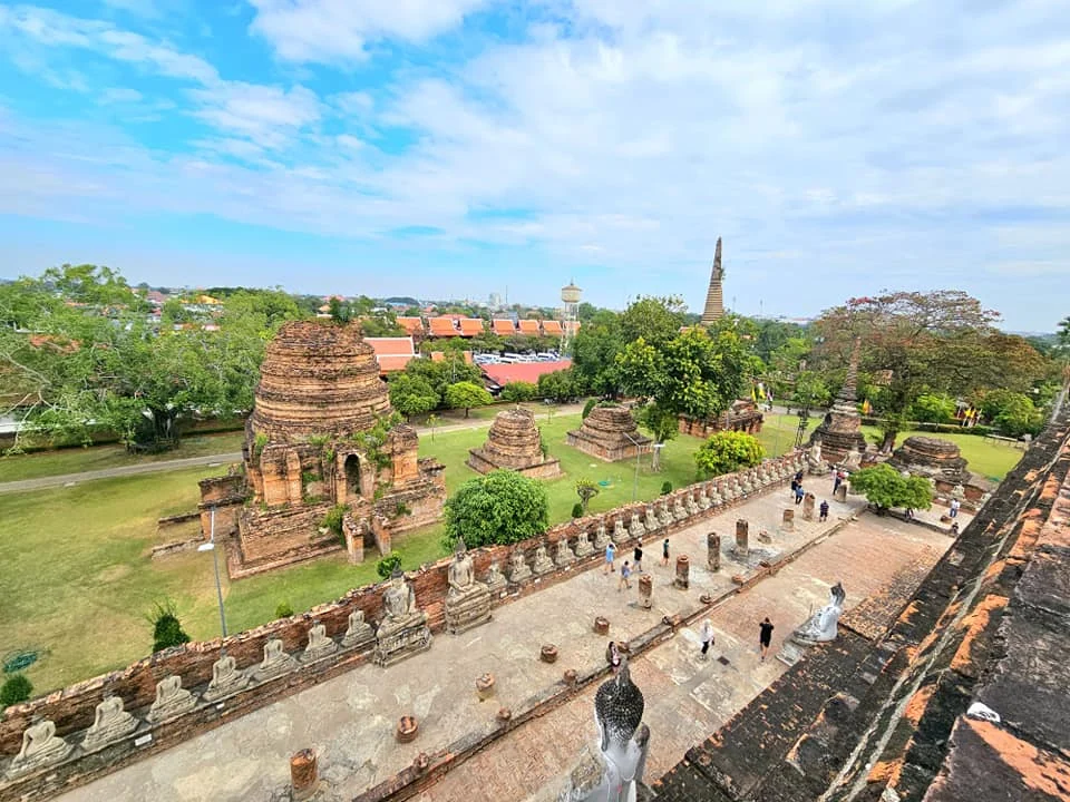 A Majestic Journey: Unveiling the Royal Historical Tour Ayutthaya from the Holland America Cruise 47 Cruising with Danny and Peter, Holland America Line, Westerdam, Laem Chabang, Bangkok, Thailand, Royal Historical Tour Ayutthaya 5 Glorious Stops | Exploring the Royal Historical Tour Ayutthaya and Bang Pa In Ayutthaya with lush gardens at Bang Pa In Palace, the elegant Aisawan Dhipaya Pavilion on a tranquil lake, towering stupa and Buddha statues at Ayutthaya Temples, colorful Traditional Thai Cuisine, and the iconic Buddha head in tree roots at Wat Mahathat Ruins—a UNESCO Heritage Site—all part of an unforgettable Thailand Cultural Tour and Ayutthaya Day Trip from the Holland America Cruise, showcasing Thai Royal History.