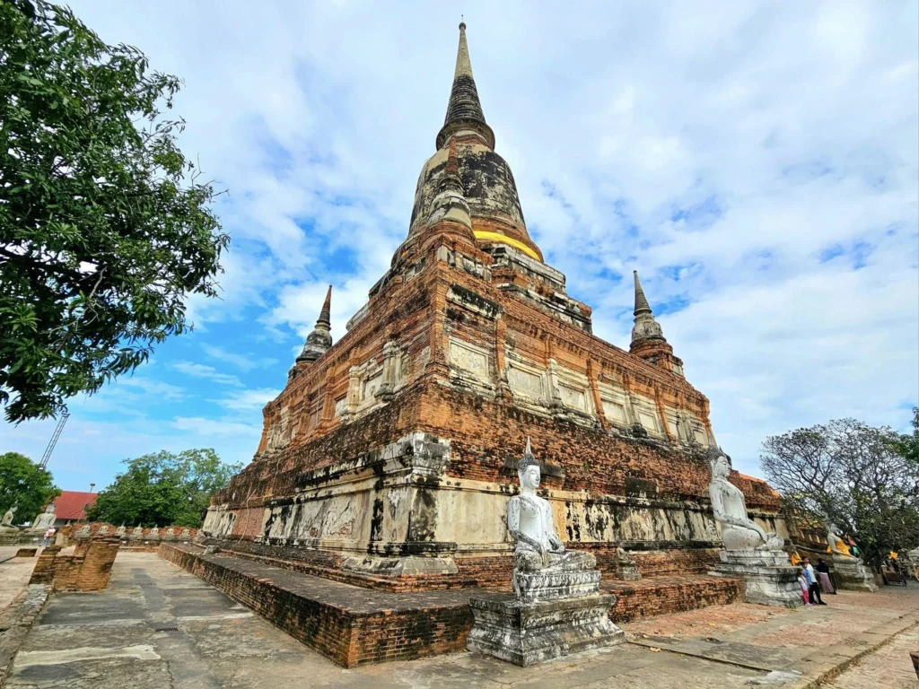 A Majestic Journey: Unveiling the Royal Historical Tour Ayutthaya from the Holland America Cruise 50 Cruising with Danny and Peter, Holland America Line, Westerdam, Laem Chabang, Bangkok, Thailand, Royal Historical Tour Ayutthaya 5 Glorious Stops | Exploring the Royal Historical Tour Ayutthaya and Bang Pa In Ayutthaya with lush gardens at Bang Pa In Palace, the elegant Aisawan Dhipaya Pavilion on a tranquil lake, towering stupa and Buddha statues at Ayutthaya Temples, colorful Traditional Thai Cuisine, and the iconic Buddha head in tree roots at Wat Mahathat Ruins—a UNESCO Heritage Site—all part of an unforgettable Thailand Cultural Tour and Ayutthaya Day Trip from the Holland America Cruise, showcasing Thai Royal History.