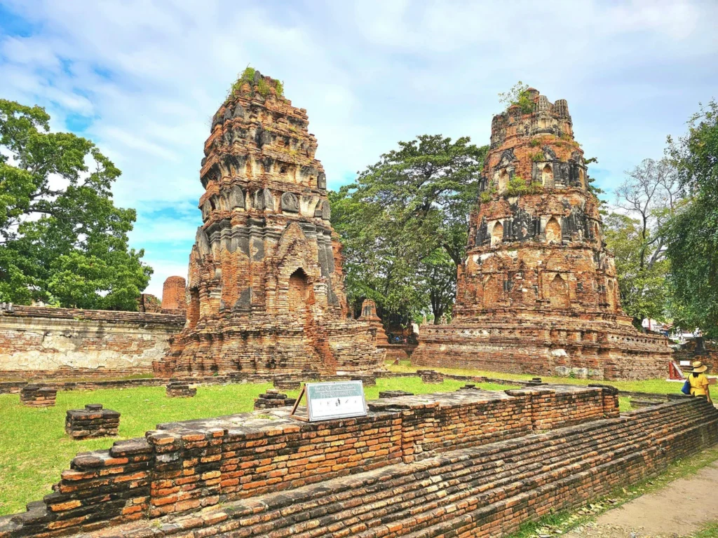 A Majestic Journey: Unveiling the Royal Historical Tour Ayutthaya from the Holland America Cruise 5 Cruising with Danny and Peter, Holland America Line, Westerdam, Laem Chabang, Bangkok, Thailand, Royal Historical Tour Ayutthaya 5 Glorious Stops | Exploring the Royal Historical Tour Ayutthaya and Bang Pa In Ayutthaya with lush gardens at Bang Pa In Palace, the elegant Aisawan Dhipaya Pavilion on a tranquil lake, towering stupa and Buddha statues at Ayutthaya Temples, colorful Traditional Thai Cuisine, and the iconic Buddha head in tree roots at Wat Mahathat Ruins—a UNESCO Heritage Site—all part of an unforgettable Thailand Cultural Tour and Ayutthaya Day Trip from the Holland America Cruise, showcasing Thai Royal History.