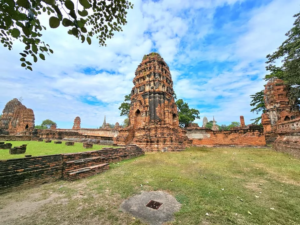 A Majestic Journey: Unveiling the Royal Historical Tour Ayutthaya from the Holland America Cruise 54 Cruising with Danny and Peter, Holland America Line, Westerdam, Laem Chabang, Bangkok, Thailand, Royal Historical Tour Ayutthaya 5 Glorious Stops | Exploring the Royal Historical Tour Ayutthaya and Bang Pa In Ayutthaya with lush gardens at Bang Pa In Palace, the elegant Aisawan Dhipaya Pavilion on a tranquil lake, towering stupa and Buddha statues at Ayutthaya Temples, colorful Traditional Thai Cuisine, and the iconic Buddha head in tree roots at Wat Mahathat Ruins—a UNESCO Heritage Site—all part of an unforgettable Thailand Cultural Tour and Ayutthaya Day Trip from the Holland America Cruise, showcasing Thai Royal History.