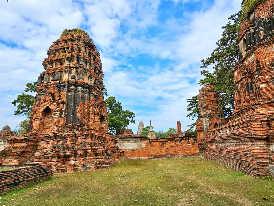 A Majestic Journey: Unveiling the Royal Historical Tour Ayutthaya from the Holland America Cruise 57 Cruising with Danny and Peter, Holland America Line, Westerdam, Laem Chabang, Bangkok, Thailand, Royal Historical Tour Ayutthaya 5 Glorious Stops | Exploring the Royal Historical Tour Ayutthaya and Bang Pa In Ayutthaya with lush gardens at Bang Pa In Palace, the elegant Aisawan Dhipaya Pavilion on a tranquil lake, towering stupa and Buddha statues at Ayutthaya Temples, colorful Traditional Thai Cuisine, and the iconic Buddha head in tree roots at Wat Mahathat Ruins—a UNESCO Heritage Site—all part of an unforgettable Thailand Cultural Tour and Ayutthaya Day Trip from the Holland America Cruise, showcasing Thai Royal History.