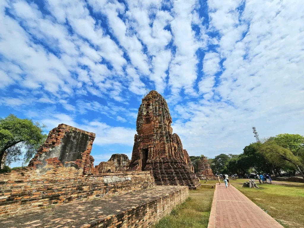 A Majestic Journey: Unveiling the Royal Historical Tour Ayutthaya from the Holland America Cruise 62 Cruising with Danny and Peter, Holland America Line, Westerdam, Laem Chabang, Bangkok, Thailand, Royal Historical Tour Ayutthaya 5 Glorious Stops | Exploring the Royal Historical Tour Ayutthaya and Bang Pa In Ayutthaya with lush gardens at Bang Pa In Palace, the elegant Aisawan Dhipaya Pavilion on a tranquil lake, towering stupa and Buddha statues at Ayutthaya Temples, colorful Traditional Thai Cuisine, and the iconic Buddha head in tree roots at Wat Mahathat Ruins—a UNESCO Heritage Site—all part of an unforgettable Thailand Cultural Tour and Ayutthaya Day Trip from the Holland America Cruise, showcasing Thai Royal History.