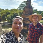 Cruising with Danny and Peter, Holland America Line, Westerdam, Laem Chabang, Bangkok, Thailand, Royal Historical Tour Ayutthaya 5 Glorious Stops | Exploring the Royal Historical Tour Ayutthaya and Bang Pa In Ayutthaya with lush gardens at Bang Pa In Palace, the elegant Aisawan Dhipaya Pavilion on a tranquil lake, towering stupa and Buddha statues at Ayutthaya Temples, colorful Traditional Thai Cuisine, and the iconic Buddha head in tree roots at Wat Mahathat Ruins—a UNESCO Heritage Site—all part of an unforgettable Thailand Cultural Tour and Ayutthaya Day Trip from the Holland America Cruise, showcasing Thai Royal History.