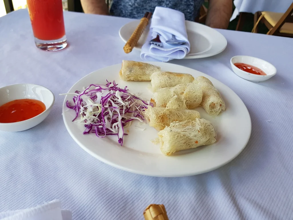 Cruising with Danny and Peter, Holland America Line, Westerdam, Nha Trang, Vietnam | Vibrant local markets in Nha Trang showcasing fresh produce and street food during a Nha Trang tour experience; scenic river cruise views with lush landscapes; delicious Vietnamese dishes like pho and banh mi from a Nha Trang food tour; historical sites featuring ancient temples and architecture in Nha Trang, Vietnam.