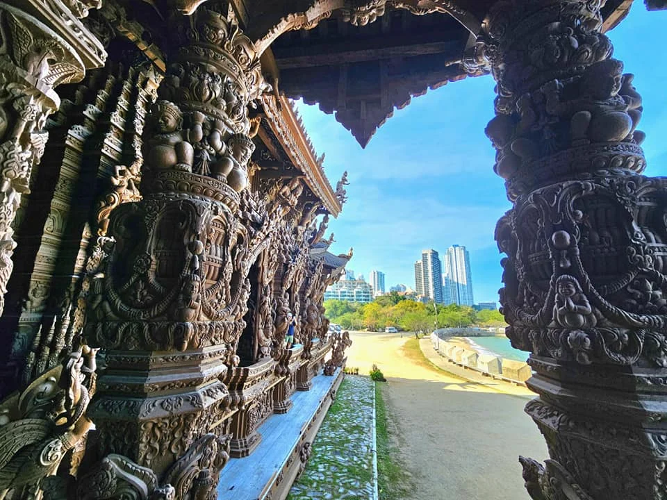 Cruising with Danny and Peter, Holland America Line, Westerdam, Laem Chabang, Bangkok, Thailand, Sanctuary Of Truth Pattaya Wonders | "Facade of the Sanctuary of Truth Pattaya showcasing intricate Thai Craftsmanship Art with towering wooden spires against a lush coastal backdrop, featuring detailed wooden carvings inside the Wooden Temple Pattaya depicting Buddhist Hindu Architecture and mythological scenes. The central hall houses a majestic wooden sculpture of a celestial deity, a highlight of Spiritual Sites Thailand and Thai Cultural Heritage. The luxurious Holland America Westerdam docked at Laem Chabang offers a Laem Chabang Excursion to explore Pattaya Cultural Landmarks, while lush greenery surrounds this Pattaya Tourist Attraction inspired by Ayutthaya Kingdom Design.