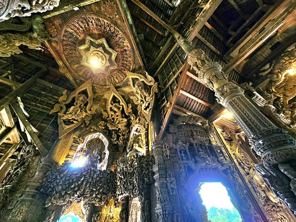 Cruising with Danny and Peter, Holland America Line, Westerdam, Laem Chabang, Bangkok, Thailand, Sanctuary Of Truth Pattaya Wonders | "Facade of the Sanctuary of Truth Pattaya showcasing intricate Thai Craftsmanship Art with towering wooden spires against a lush coastal backdrop, featuring detailed wooden carvings inside the Wooden Temple Pattaya depicting Buddhist Hindu Architecture and mythological scenes. The central hall houses a majestic wooden sculpture of a celestial deity, a highlight of Spiritual Sites Thailand and Thai Cultural Heritage. The luxurious Holland America Westerdam docked at Laem Chabang offers a Laem Chabang Excursion to explore Pattaya Cultural Landmarks, while lush greenery surrounds this Pattaya Tourist Attraction inspired by Ayutthaya Kingdom Design.