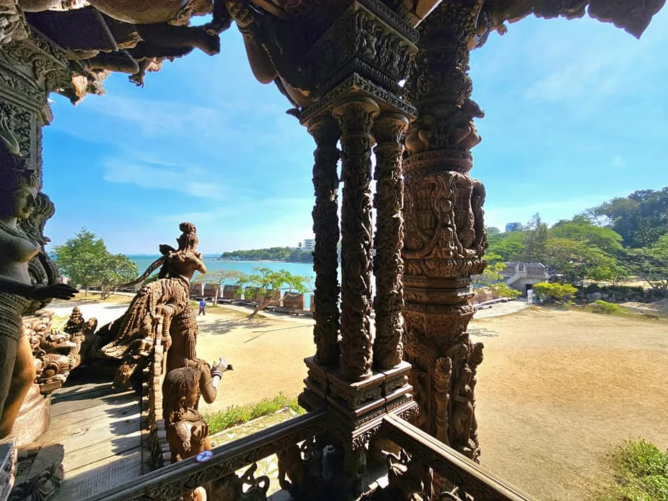 Cruising with Danny and Peter, Holland America Line, Westerdam, Laem Chabang, Bangkok, Thailand, Sanctuary Of Truth Pattaya Wonders | "Facade of the Sanctuary of Truth Pattaya showcasing intricate Thai Craftsmanship Art with towering wooden spires against a lush coastal backdrop, featuring detailed wooden carvings inside the Wooden Temple Pattaya depicting Buddhist Hindu Architecture and mythological scenes. The central hall houses a majestic wooden sculpture of a celestial deity, a highlight of Spiritual Sites Thailand and Thai Cultural Heritage. The luxurious Holland America Westerdam docked at Laem Chabang offers a Laem Chabang Excursion to explore Pattaya Cultural Landmarks, while lush greenery surrounds this Pattaya Tourist Attraction inspired by Ayutthaya Kingdom Design.