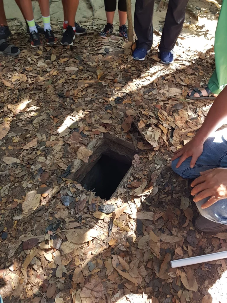 Cruising with Danny and Peter, Holland America Line, Westerdam, Phu My, Vietnam | Visitors exploring the Cu Chi Tunnels, a historic underground network used during the Vietnam War near Ho Chi Minh City, showcasing the Viet Cong's guerrilla tactics and the resilience of the Vietnamese people. The intricate tunnels of Cu Chi, complete with living quarters, are an iconic part of Vietnam's cultural heritage and historical sites, providing insight into underground warfare and the country's wartime history.