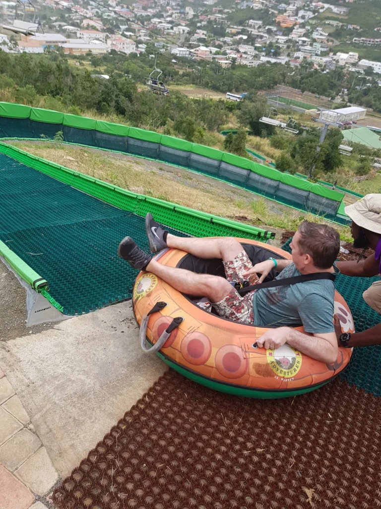 Cruising with Danny and Peter, Holland America Line, Zuiderdam, Philipsburg, Sint-Maarten | Adventurers soaring through the sky on the Philipsburg zip-line, enjoying breathtaking scenic views of lush Caribbean landscapes, turquoise waters, and the charming architecture of Philipsburg during an exhilarating aerial adventure.