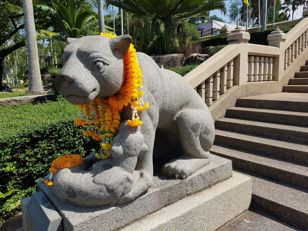 Cruising with Danny and Peter, Holland America Line, Westerdam, Laem Chabang, Bangkok, Thailand | A serene view of Wat Yan Nasangwararam temple in Pattaya, showcasing intricate Thai architecture surrounded by lush greenery. In the foreground, worshippers engage in meditation and tranquility, while the majestic Khao Chi Chan Buddha monument looms in the background, radiating serenity. This scene captures the essence of a spiritual journey in Pattaya, highlighting the cultural heritage of Thai Buddhism and the beauty of religious art in Thailand.