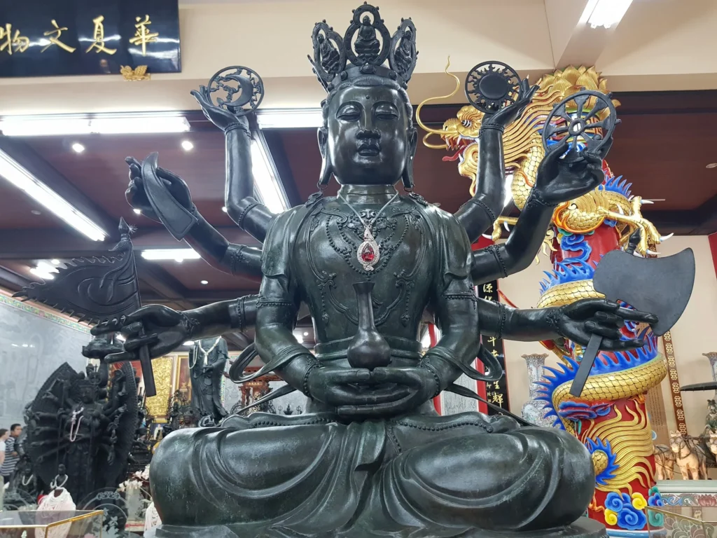 Cruising with Danny and Peter, Holland America Line, Westerdam, Laem Chabang, Bangkok, Thailand | A serene view of Wat Yan Nasangwararam temple in Pattaya, showcasing intricate Thai architecture surrounded by lush greenery. In the foreground, worshippers engage in meditation and tranquility, while the majestic Khao Chi Chan Buddha monument looms in the background, radiating serenity. This scene captures the essence of a spiritual journey in Pattaya, highlighting the cultural heritage of Thai Buddhism and the beauty of religious art in Thailand.