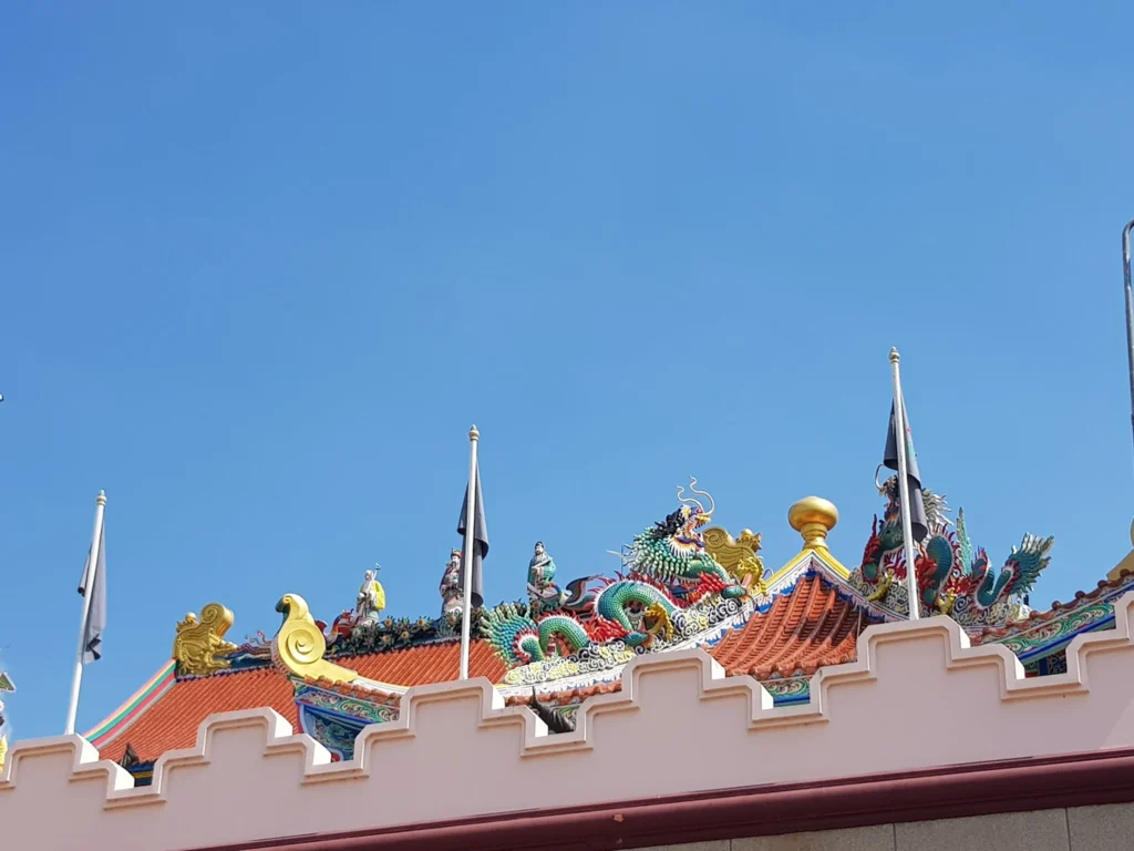 Cruising with Danny and Peter, Holland America Line, Westerdam, Laem Chabang, Bangkok, Thailand | A serene view of Wat Yan Nasangwararam temple in Pattaya, showcasing intricate Thai architecture surrounded by lush greenery. In the foreground, worshippers engage in meditation and tranquility, while the majestic Khao Chi Chan Buddha monument looms in the background, radiating serenity. This scene captures the essence of a spiritual journey in Pattaya, highlighting the cultural heritage of Thai Buddhism and the beauty of religious art in Thailand.