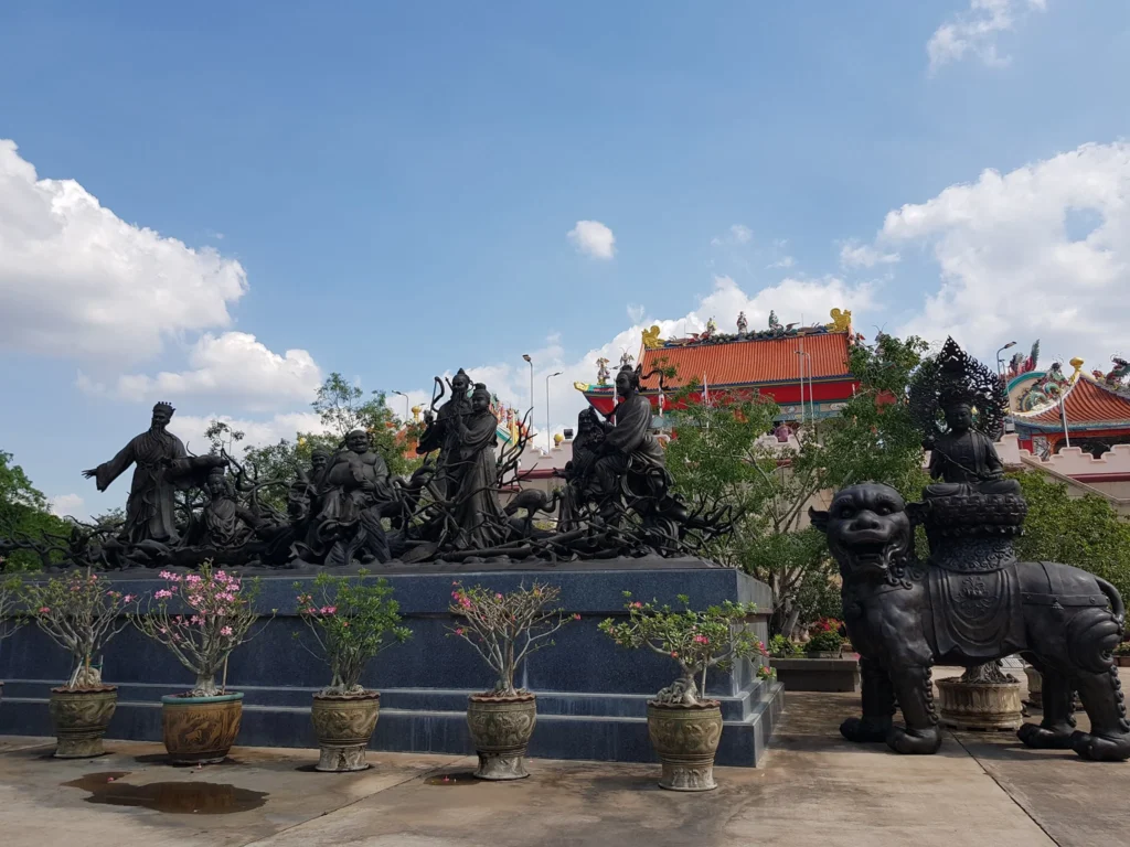 Cruising with Danny and Peter, Holland America Line, Westerdam, Laem Chabang, Bangkok, Thailand | A serene view of Wat Yan Nasangwararam temple in Pattaya, showcasing intricate Thai architecture surrounded by lush greenery. In the foreground, worshippers engage in meditation and tranquility, while the majestic Khao Chi Chan Buddha monument looms in the background, radiating serenity. This scene captures the essence of a spiritual journey in Pattaya, highlighting the cultural heritage of Thai Buddhism and the beauty of religious art in Thailand.