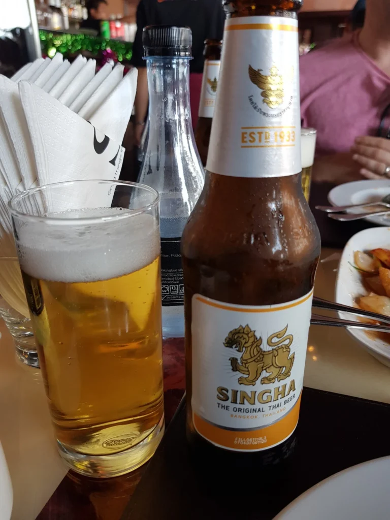 Cruising with Danny and Peter, Holland America Line, Westerdam, Laem Chabang, Bangkok, Thailand | A serene view of Wat Yan Nasangwararam temple in Pattaya, showcasing intricate Thai architecture surrounded by lush greenery. In the foreground, worshippers engage in meditation and tranquility, while the majestic Khao Chi Chan Buddha monument looms in the background, radiating serenity. This scene captures the essence of a spiritual journey in Pattaya, highlighting the cultural heritage of Thai Buddhism and the beauty of religious art in Thailand.
