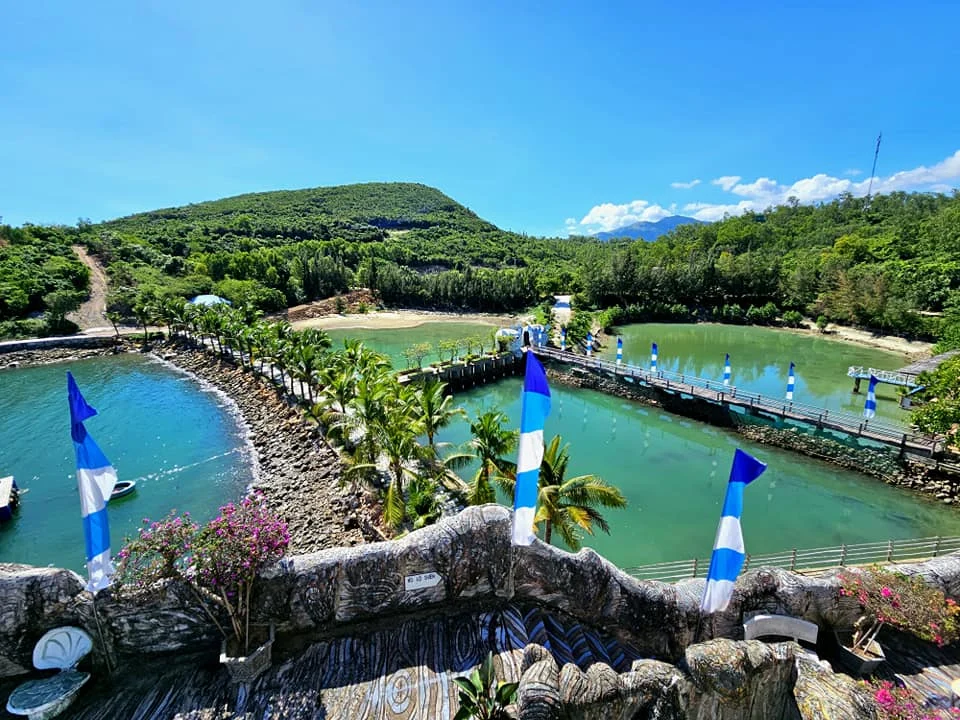 Cruising with Danny and Peter, Holland America Line, Westerdam, Nha Trang, Vietnam, Nha Trang Island Escapade Adventure | Group of tourists enjoying a Nha Trang Island Escapade Adventure featuring Mieu Island Exploration under a tropical sun, vibrant underwater scenes from Coral Reef Snorkeling in Nha Trang Bay, the pirate ship-shaped Tri Nguyen Aquarium showcasing a Marine Life Experience on a Vietnam Coastal Adventure, local fishermen feeding groupers during a Fishing Village Visit, relaxing on golden sands at Mini Beach Relaxation after a Nha Trang Island Tour with Holland America Cruise, and a scenic view of Nha Trang Bay from a boat during a Tropical Island Retreat.