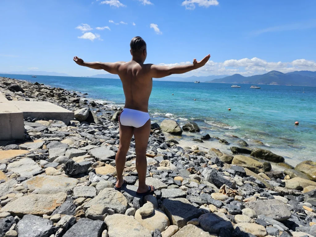 Cruising with Danny and Peter, Holland America Line, Westerdam, Nha Trang, Vietnam, Nha Trang Island Escapade Adventure | Group of tourists enjoying a Nha Trang Island Escapade Adventure featuring Mieu Island Exploration under a tropical sun, vibrant underwater scenes from Coral Reef Snorkeling in Nha Trang Bay, the pirate ship-shaped Tri Nguyen Aquarium showcasing a Marine Life Experience on a Vietnam Coastal Adventure, local fishermen feeding groupers during a Fishing Village Visit, relaxing on golden sands at Mini Beach Relaxation after a Nha Trang Island Tour with Holland America Cruise, and a scenic view of Nha Trang Bay from a boat during a Tropical Island Retreat.