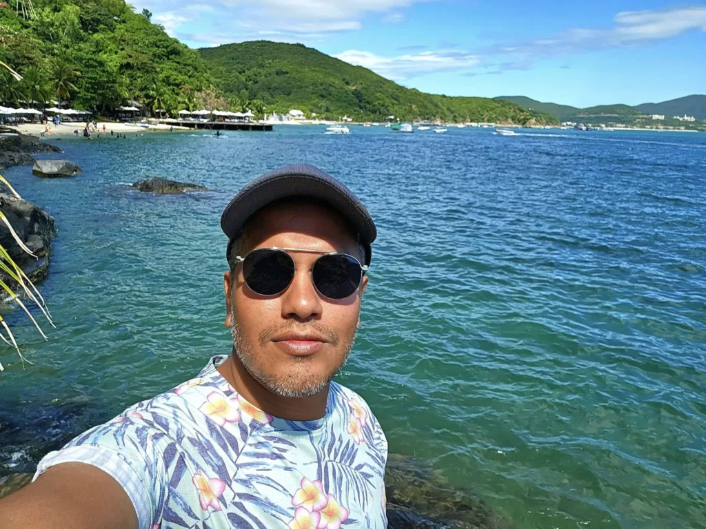 Cruising with Danny and Peter, Holland America Line, Westerdam, Nha Trang, Vietnam, Nha Trang Island Escapade Adventure | Group of tourists enjoying a Nha Trang Island Escapade Adventure featuring Mieu Island Exploration under a tropical sun, vibrant underwater scenes from Coral Reef Snorkeling in Nha Trang Bay, the pirate ship-shaped Tri Nguyen Aquarium showcasing a Marine Life Experience on a Vietnam Coastal Adventure, local fishermen feeding groupers during a Fishing Village Visit, relaxing on golden sands at Mini Beach Relaxation after a Nha Trang Island Tour with Holland America Cruise, and a scenic view of Nha Trang Bay from a boat during a Tropical Island Retreat.