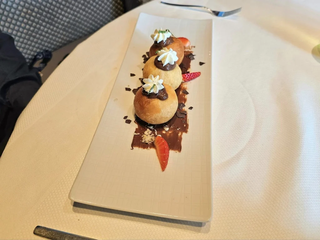 Cruising with Danny and Peter, Holland America Line, Westerdam, Nha Trang, Vietnam, Nha Trang Island Escapade Adventure | Group of tourists enjoying a Nha Trang Island Escapade Adventure featuring Mieu Island Exploration under a tropical sun, vibrant underwater scenes from Coral Reef Snorkeling in Nha Trang Bay, the pirate ship-shaped Tri Nguyen Aquarium showcasing a Marine Life Experience on a Vietnam Coastal Adventure, local fishermen feeding groupers during a Fishing Village Visit, relaxing on golden sands at Mini Beach Relaxation after a Nha Trang Island Tour with Holland America Cruise, and a scenic view of Nha Trang Bay from a boat during a Tropical Island Retreat.