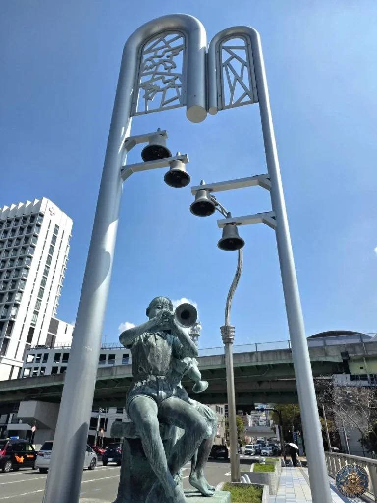 Boy with trumpet sculpture and bell tower at Mirai Nagasaki Coco Walk near the Ferris wheel, a popular stop in Nagasaki Japan cruise port guide. Perfect for things to do in Nagasaki from cruise ship and one day in Nagasaki Japan itinerary when visiting from the Westerdam by Danny and Peter.