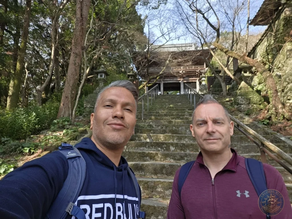 Danny and Peter taking a selfie at the stone steps of Chikurin Temple in Kochi, Japan. Traditional temple architecture surrounded by lush forest and trees. Kochi Cruise Port Guide | Things to do in Kochi from cruise ship | One day in Kochi Japan itinerary by Danny and Peter.