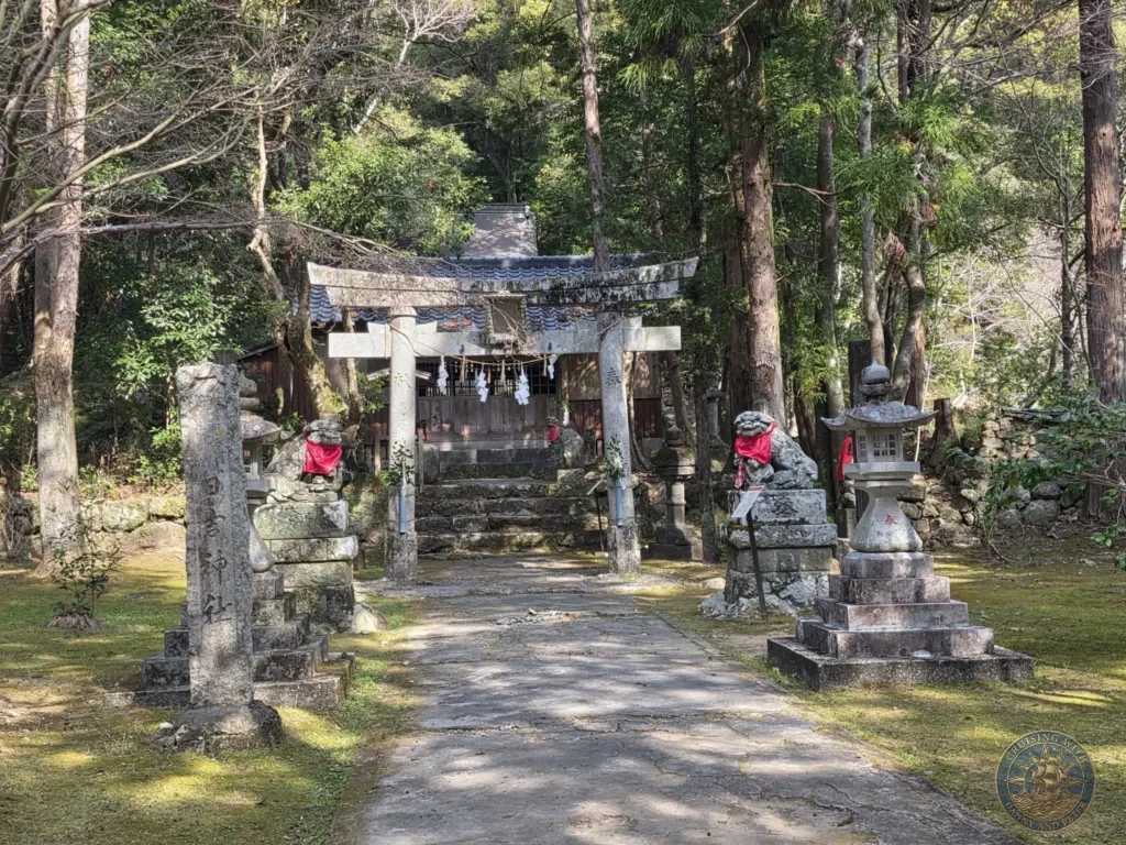 Stone torii gate flanked by komainu guardian statues and lanterns leading to a shrine at Chikurin Temple in Kochi, Japan. Peaceful forested temple grounds with traditional stone elements. Kochi Cruise Port Guide | Things to do in Kochi from cruise ship | One day in Kochi Japan itinerary by Danny and Peter.