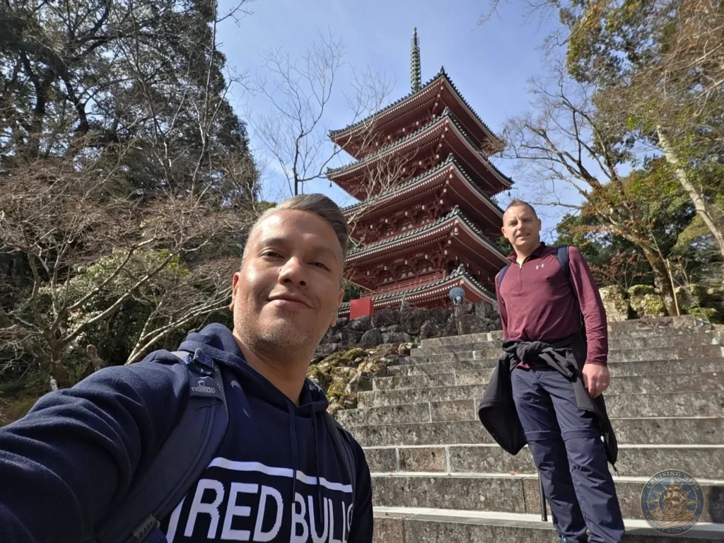 Danny and Peter taking a selfie in front of the iconic five-story red pagoda at Chikurin Temple in Kochi, Japan. Stone stairs and lush trees in the scenic temple grounds. Kochi Cruise Port Guide | Things to do in Kochi from cruise ship | One day in Kochi Japan itinerary by Danny and Peter.