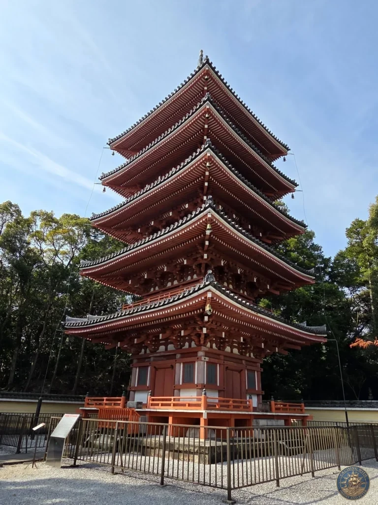 Iconic five-story red pagoda at Chikurin Temple in Kochi, Japan. Striking traditional architecture rising against a clear blue sky with surrounding trees. Kochi Cruise Port Guide | Things to do in Kochi from cruise ship | One day in Kochi Japan itinerary by Danny and Peter.