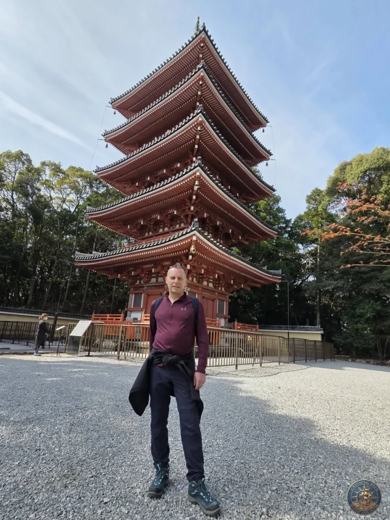 Peter standing proudly in front of the iconic five-story red pagoda at Chikurin Temple in Kochi, Japan. Beautiful traditional architecture with clear blue sky and trees. Kochi Cruise Port Guide | Things to do in Kochi from cruise ship | One day in Kochi Japan itinerary by Danny and Peter.