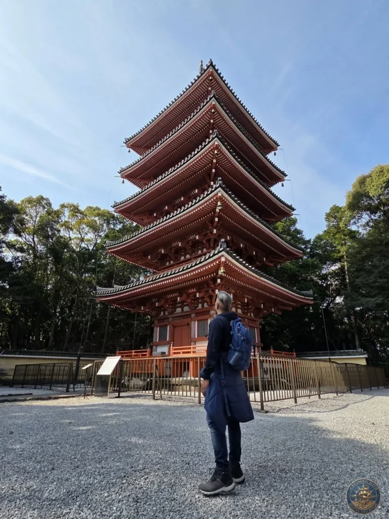 Danny standing in front of the iconic five-story red pagoda at Chikurin Temple in Kochi, Japan. Beautiful traditional architecture with gravel grounds and trees. Kochi Cruise Port Guide | Things to do in Kochi from cruise ship | One day in Kochi Japan itinerary by Danny and Peter.