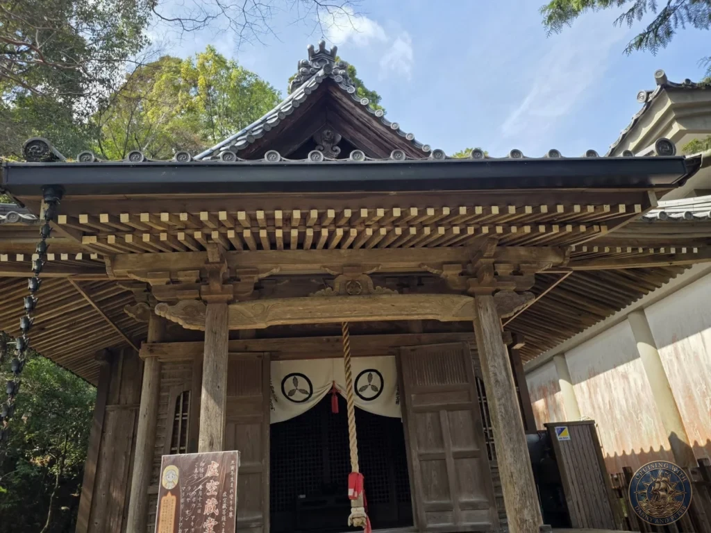 Ornate traditional wooden entrance with detailed roof carvings and bell rope at Chikurin Temple in Kochi, Japan. Beautiful historic temple architecture. Kochi Cruise Port Guide | Things to do in Kochi from cruise ship | One day in Kochi Japan itinerary by Danny and Peter.