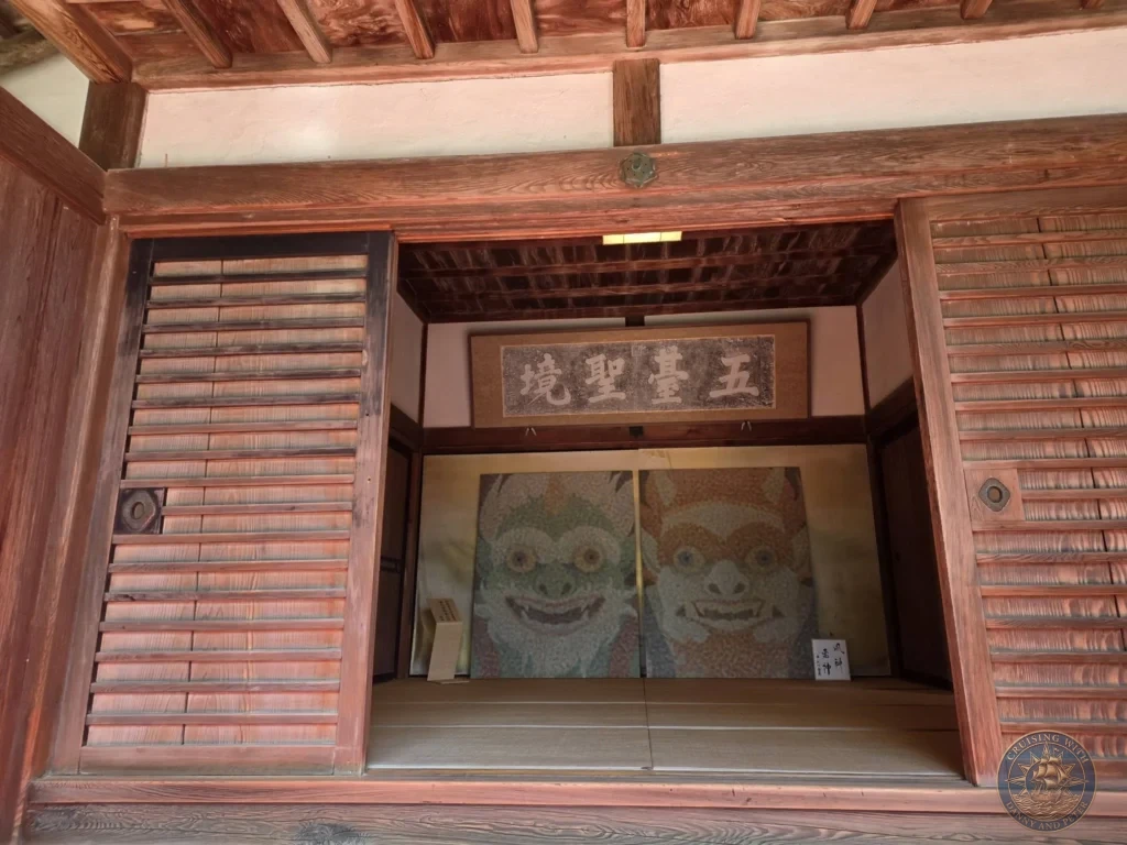 View into a traditional wooden temple hall at Chikurin Temple in Kochi, Japan, showing sliding doors, wooden shutters, and guardian artwork. Historic Japanese architecture. Kochi Cruise Port Guide | Things to do in Kochi from cruise ship | One day in Kochi Japan itinerary by Danny and Peter.