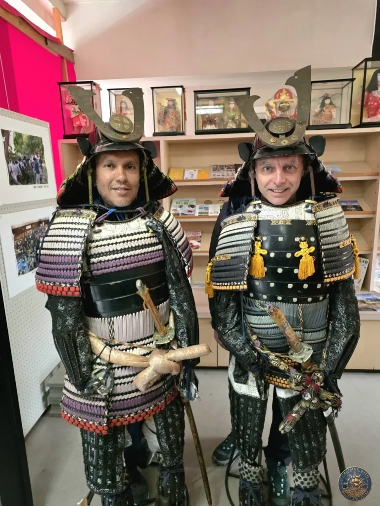 Danny and Peter trying on traditional samurai armor at the Chiran Doll & Toy Museum gift shop in the Chiran Samurai District. Fun interactive experience during a shore excursion in Kagoshima, Japan. Kagoshima Cruise Port Guide | Things to do in Kagoshima from cruise ship | One day in Kagoshima Japan itinerary by Danny and Peter.