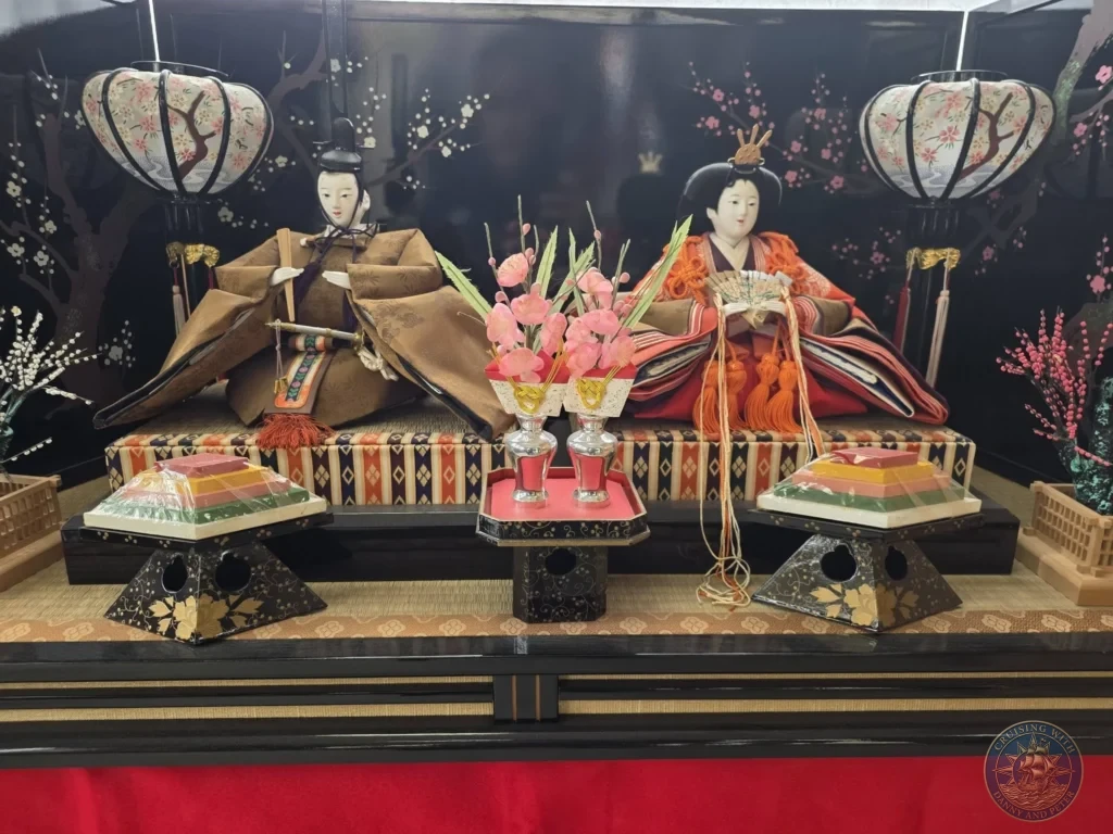 Elegant traditional Hina-ningyo doll display featuring Emperor and Empress dolls in ornate kimono with accessories and lanterns at the Chiran Doll & Toy Museum. Beautiful exhibit in the Chiran Samurai District, Kagoshima, Japan. Kagoshima Cruise Port Guide | Things to do in Kagoshima from cruise ship | One day in Kagoshima Japan itinerary by Danny and Peter.